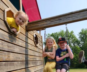 Young children at Quaker Knoll playground equipment